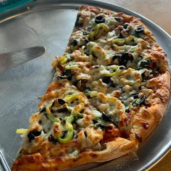 Half of a Mama Mia's Italian pizza with black olives, green peppers, and melted cheese.